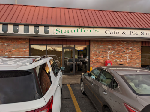 Exterior of Stauffer's Cafe & Pie Shop, featuring a brick facade and parked cars in front.