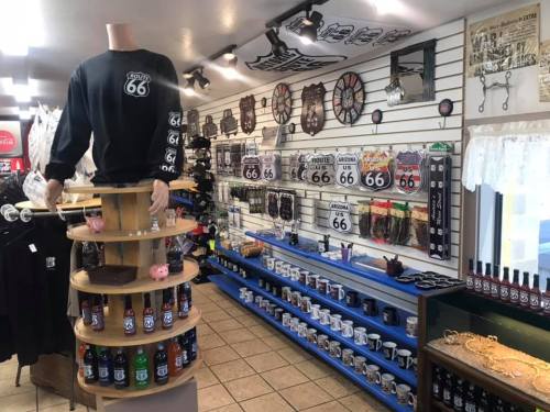 A souvenir shop displaying Route 66 merchandise, including clothing, signs, mugs, and various collectibles.
