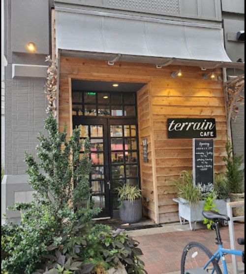 Entrance of Terrain Café featuring wooden exterior, plants, and a bicycle parked outside.