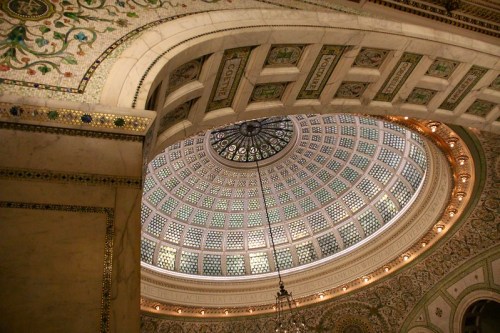 Intricate dome with colorful glass and detailed architectural patterns, illuminated from above.