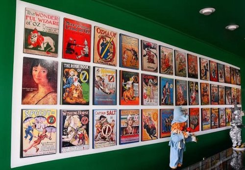 A wall display featuring vintage book covers and illustrations, including "The Wonderful Wizard of Oz" and others.