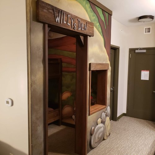 A whimsical entrance labeled "Wiley's Den" with a mural and a cozy nook visible inside.