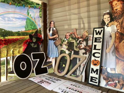 A porch display featuring "Oz" signs, characters from "The Wizard of Oz," and a welcoming sign.