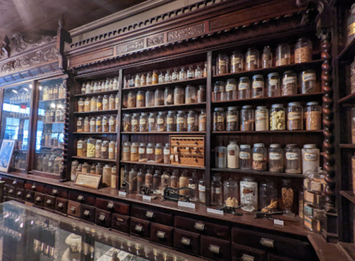 A vintage apothecary shelf filled with jars of herbs, spices, and various natural ingredients.