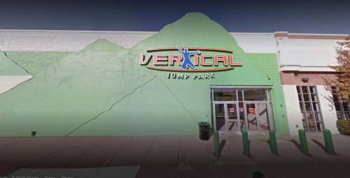 Exterior of Vertical Jump Park, featuring a green wall and a colorful sign above the entrance.