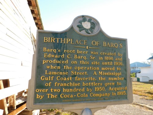 Sign detailing the birthplace of Barq's root beer, highlighting its history and acquisition by Coca-Cola in 1995.