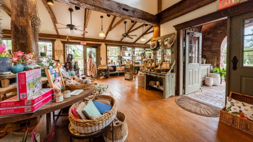 A cozy shop interior with wooden beams, shelves of products, and decorative items, creating a warm, inviting atmosphere.