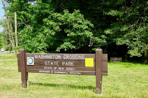 Sign for Washington Crossing State Park in New Jersey, surrounded by green trees and grass.