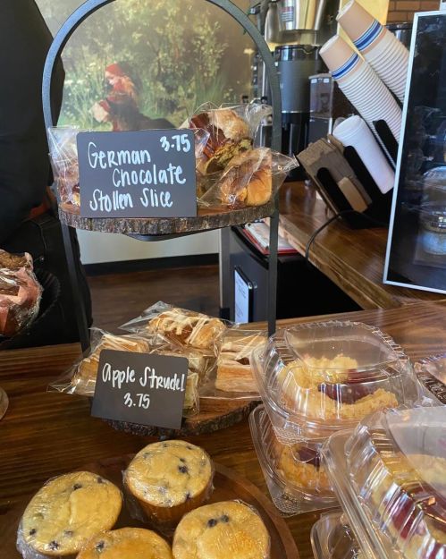 A display of baked goods including German chocolate stollen slices and apple strudel, with prices listed.