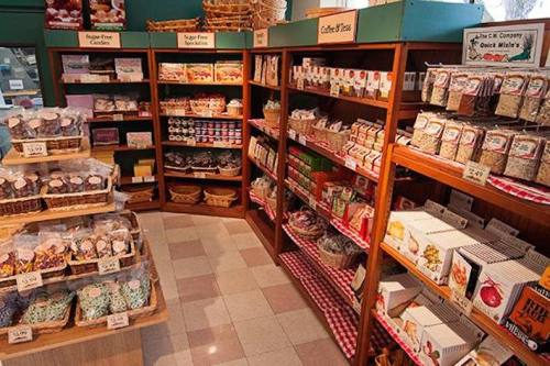 A cozy shop interior with shelves filled with various snacks, candies, and packaged goods in baskets.