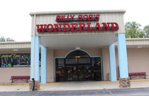 Entrance of Billy Bob's Wonderland, featuring a large sign and benches outside the building.