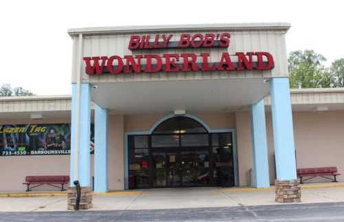 Entrance of Billy Bob's Wonderland, featuring a large sign and benches outside the building.