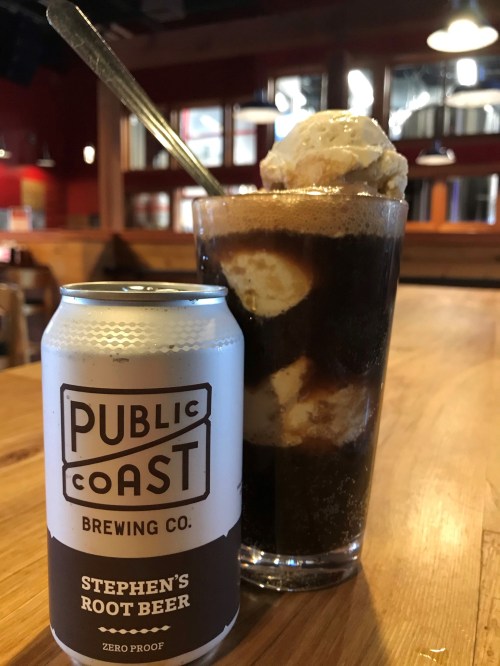 A glass of root beer float with ice cream, next to a can of Public Coast Brewing Co. Stephen's Root Beer.