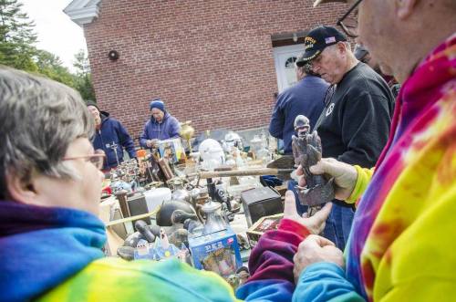 A vibrant outdoor flea market scene with people browsing various antiques and collectibles.