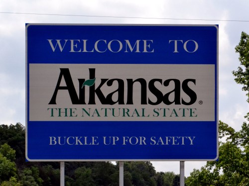 Welcome sign for Arkansas, featuring "The Natural State" and a reminder to buckle up for safety.