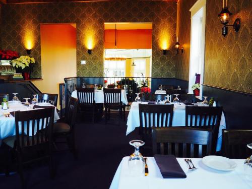 Cozy restaurant interior with tables set for dining, warm lighting, and festive decorations.