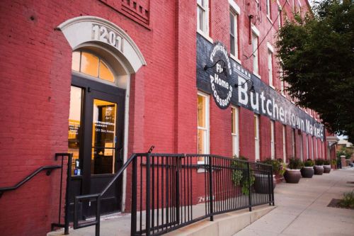 Exterior of a red brick building with a sign reading "Butchertown Market" and a ramp leading to the entrance.