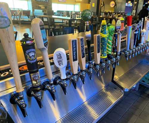 A row of beer taps with various handles at a bar, showcasing a variety of craft beers.