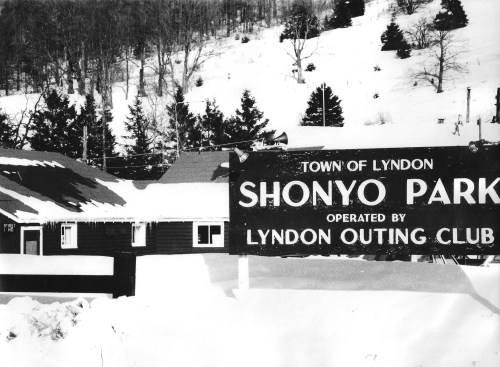 Sign for Shonyo Park in winter, with snow-covered ground and trees in the background.