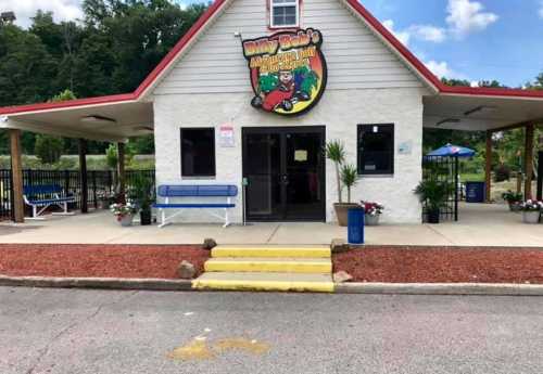 Exterior of Billy Bob's indoor mini-golf and fun center, featuring a colorful sign and landscaped entrance.