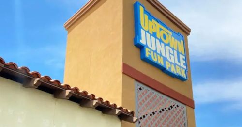 Sign for "Uptown Jungle Fun Park" on a building with a blue sky in the background.