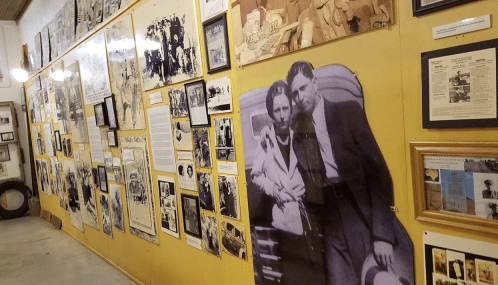 A wall covered with historical photographs and documents, featuring a large black-and-white image of a couple.