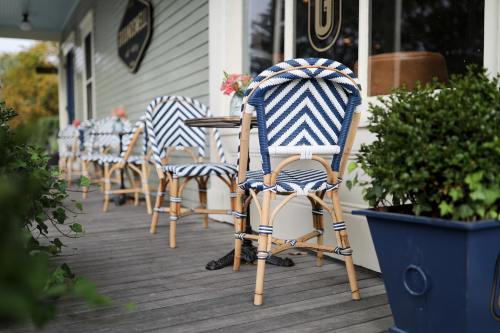 Outdoor café scene featuring striped chairs and potted plants on a wooden deck.