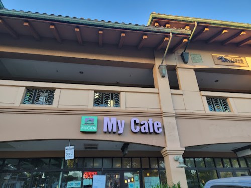 Exterior of a cafe building with a sign reading "My Cafe" and an open sign in the window.