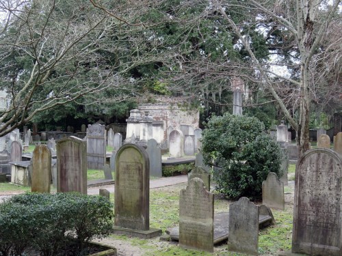 A peaceful cemetery with various gravestones surrounded by trees and greenery.