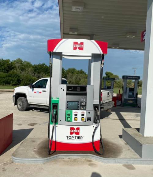 A Cenex gas pump at a station, with a pickup truck parked nearby and another pump in the background.