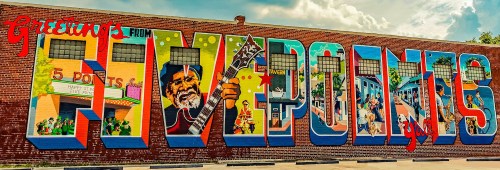 Colorful mural reading "Greetings from 5 Points," featuring vibrant scenes and characters celebrating the area.