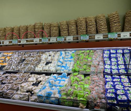 A grocery display featuring various packaged foods, including noodles and colorful snacks, arranged in baskets and trays.