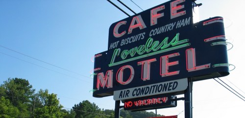 Sign for Loveless Motel and Cafe, featuring neon lights and text about food and air conditioning, with "No Vacancy" displayed.