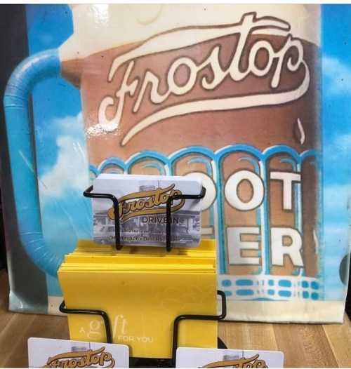 A display of gift cards in front of a vintage "Frostop" sign featuring a frosty mug of beer.