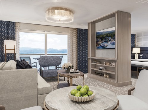 A modern hotel suite with a seating area, large window view, and stylish decor, featuring a TV and decorative elements.
