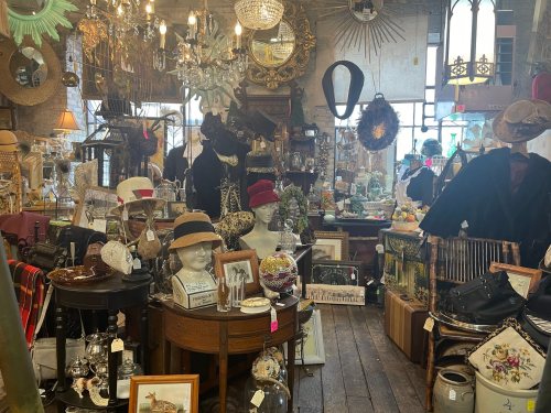 A cozy antique shop filled with vintage hats, decor, and various collectibles, creating a charming, eclectic atmosphere.