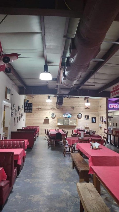 Interior of a diner with red booths, wooden tables, and vintage decor, featuring a cozy, inviting atmosphere.