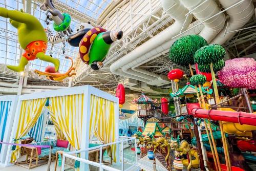 Colorful indoor water park with whimsical decorations, slides, and play areas for children. Bright and playful atmosphere.