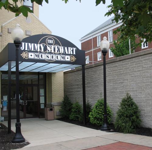 Entrance to the Jimmy Stewart Museum, featuring a sign and landscaped surroundings.