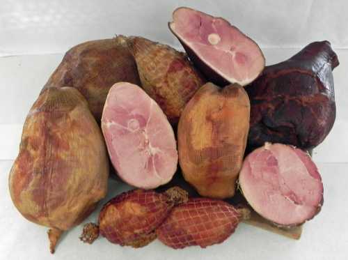 A variety of cured hams displayed on a white background, showcasing different shapes and sizes.