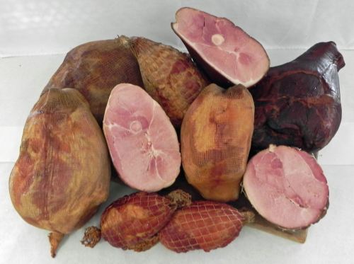 A variety of cured hams displayed on a white background, showcasing different shapes and sizes.