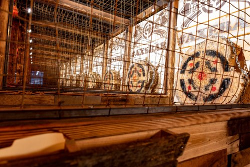 A wooden structure with a grid, showcasing circular targets with colorful designs inside.