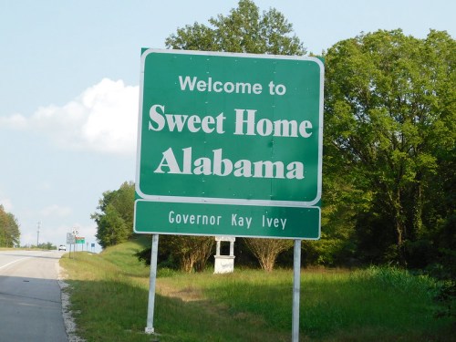 Green welcome sign for Alabama, reading "Welcome to Sweet Home Alabama," with Governor Kay Ivey's name below.