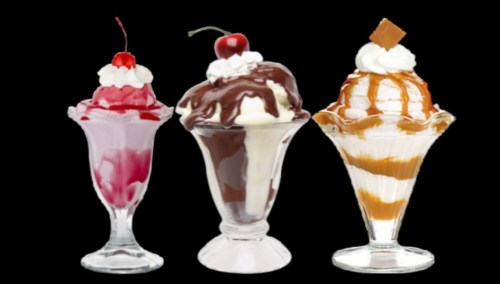Three colorful ice cream sundaes in glass dishes, topped with whipped cream, cherries, and chocolate or caramel sauce.