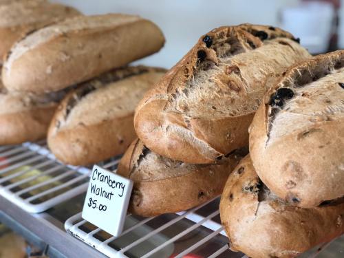 Freshly baked cranberry walnut loaves displayed on a rack, with a price tag of $5.00.