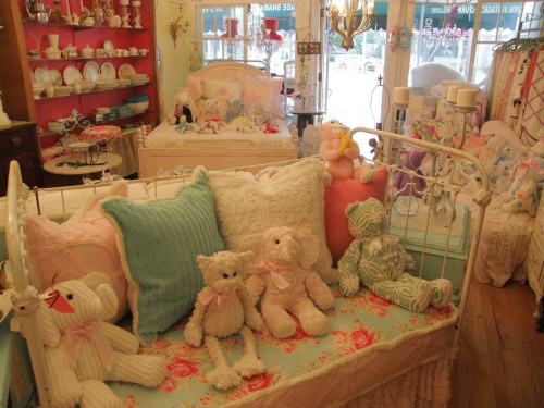 A cozy room with vintage beds, colorful pillows, and plush teddy bears, creating a charming, whimsical atmosphere.