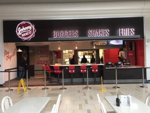 A Johnny Rockets restaurant featuring a menu of burgers, shakes, and fries, with a modern diner-style interior.