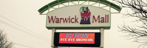 Sign for Warwick Mall featuring "GO PATS! BYE BYE BRONCOS" in bright red letters.