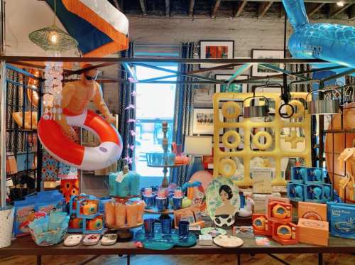 A vibrant display of summer-themed decor and accessories, featuring inflatable items, colorful containers, and beach motifs.