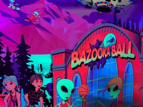 Colorful cartoon scene featuring aliens, kids, and a vibrant "Bazooka Ball" sign against a mountain backdrop.